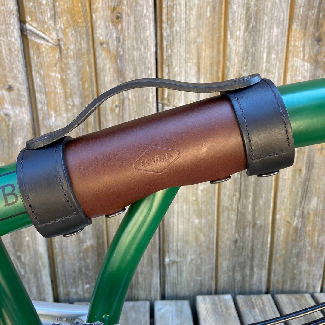 Brown and black carry handle on green brompton