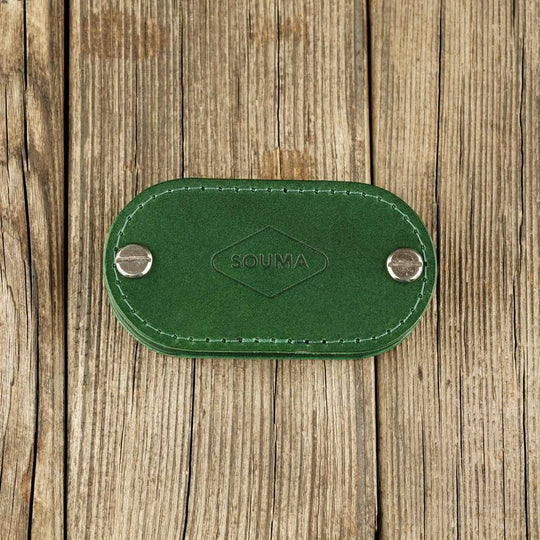 Green key organizer on wooden background