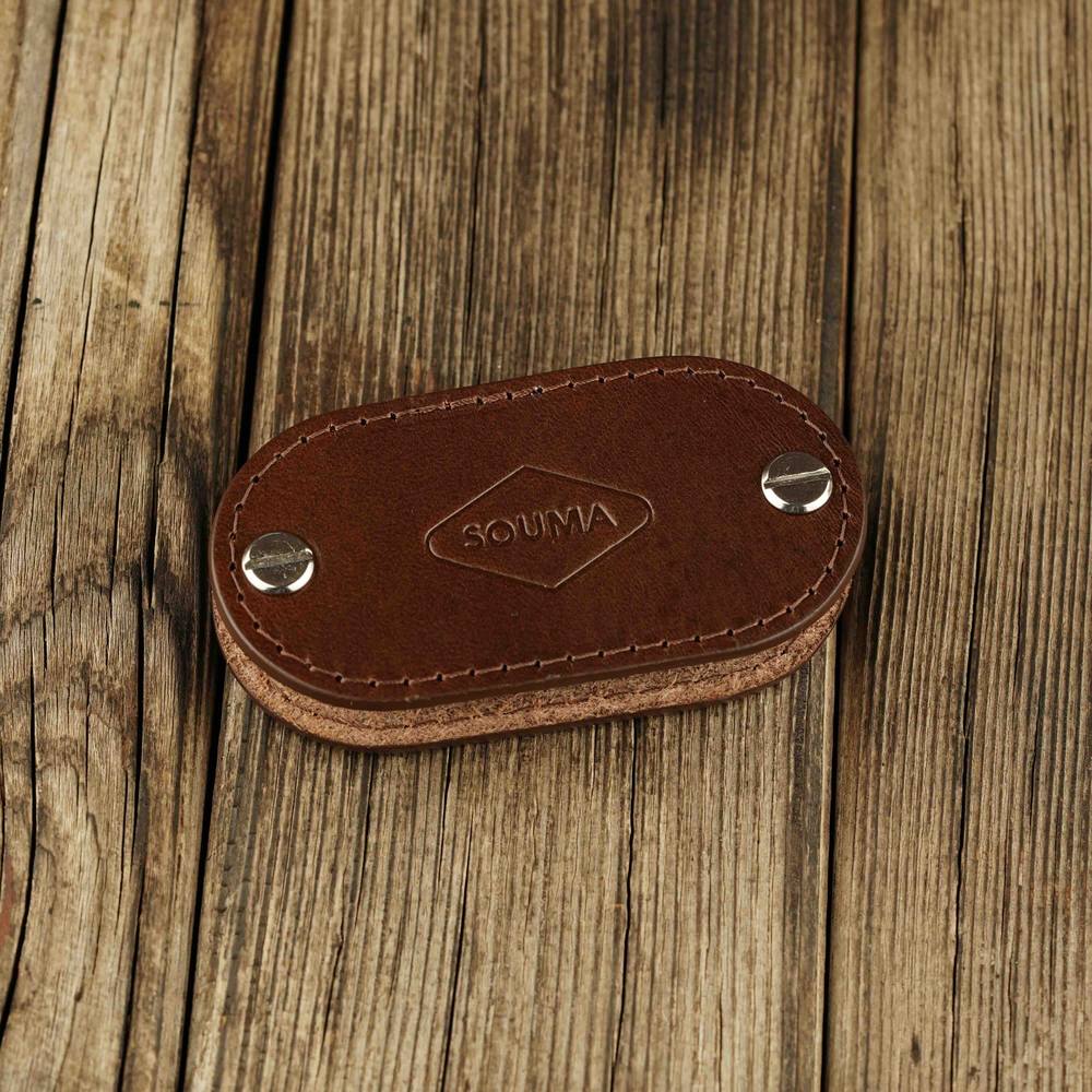 Brown leather key organizer on a wooden surface