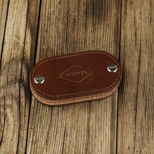 Brown leather key organizer on a wooden surface