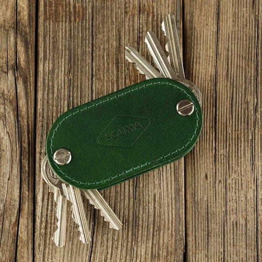 Green key organizer with keys on a wooden surface