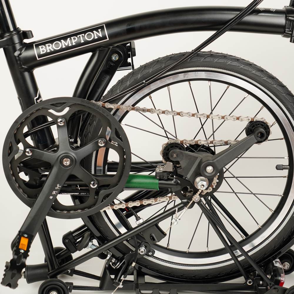 green leather chain and hook protector on half folded Brompton 