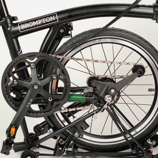 green leather chain and hook protector on half folded Brompton 