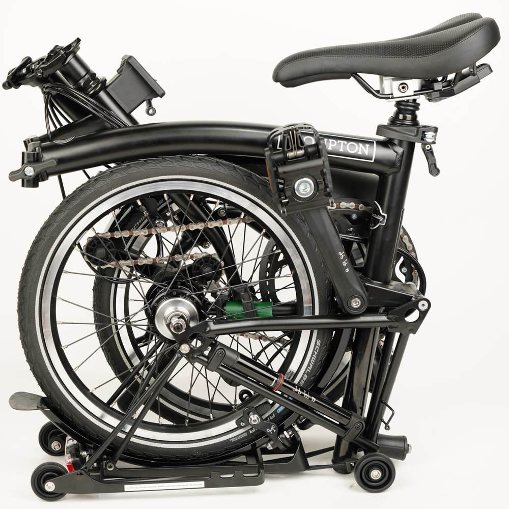 Folded Brompton bike with green leather chain and hook protector