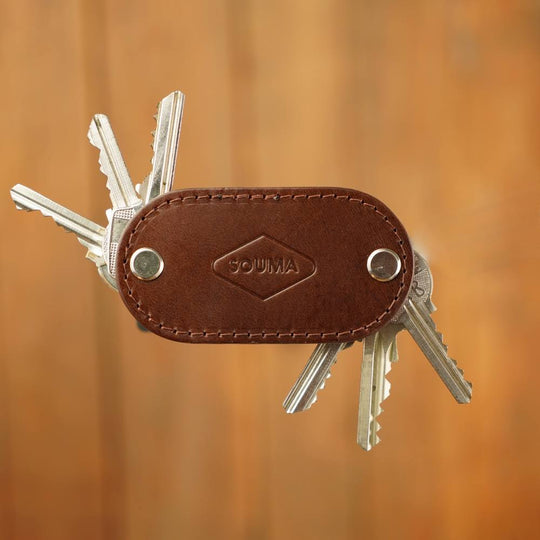 Apple AirTag organizer in brown color with keys out on brown background