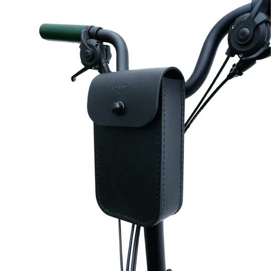 Black leather handlebar bag attached to a bicycle handlebar on a white background
