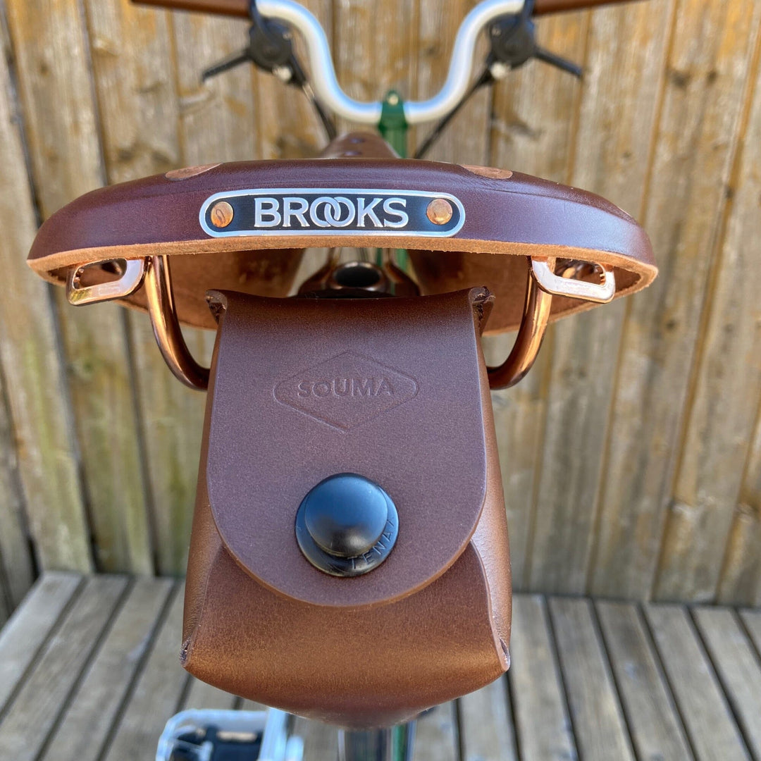 Brompton saddle bag brown with black hardware closure on wooden background